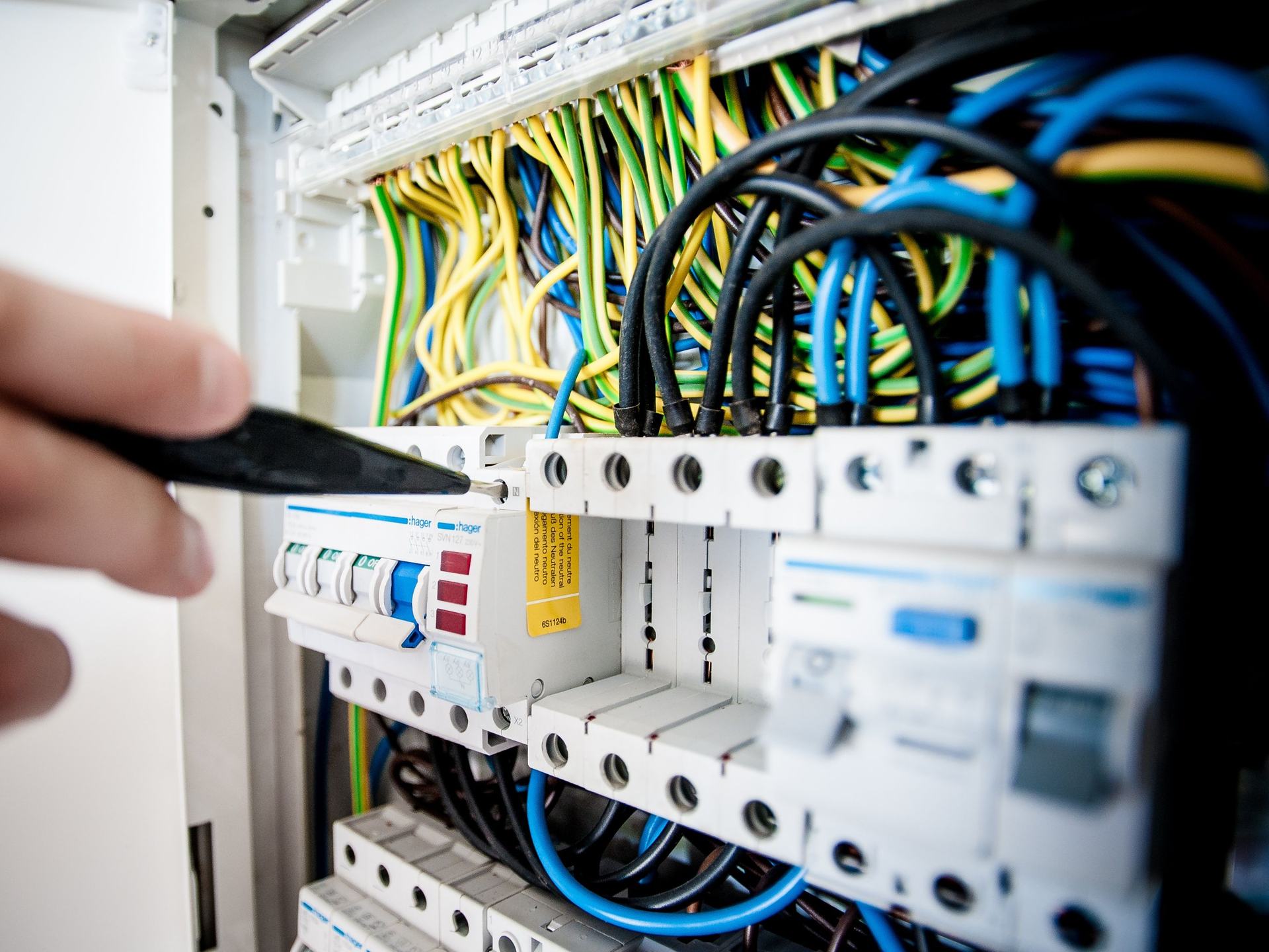 An electrician testing circuits at a domestic consumer unit during an EICR inspection