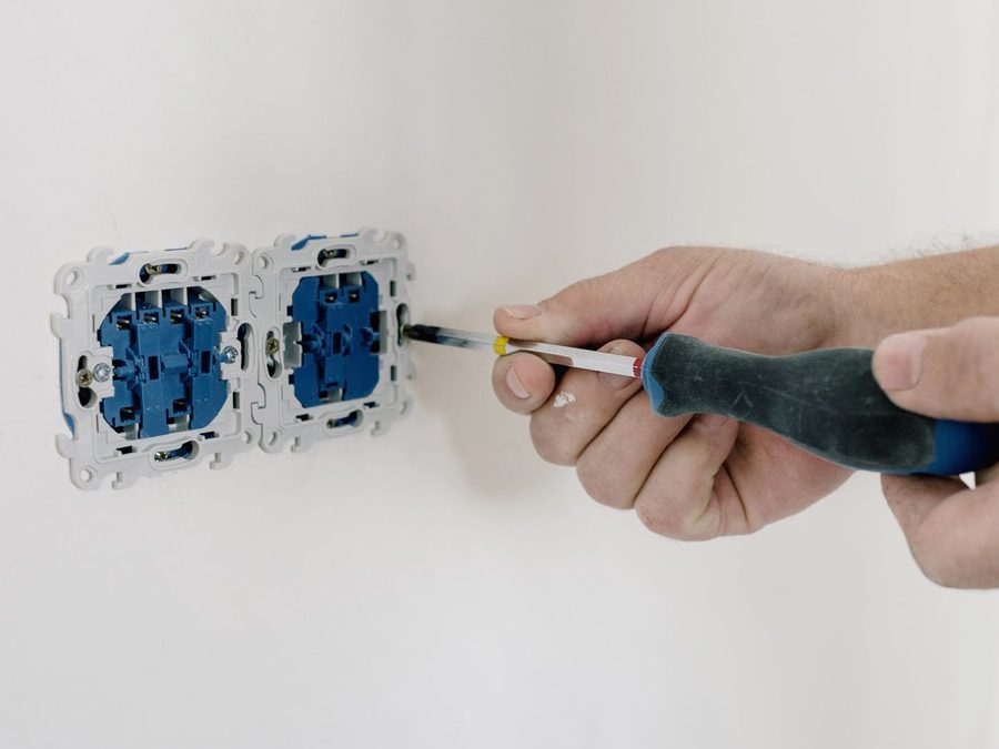 Electrician working inside an open consumer unit